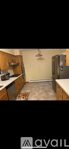 A kitchen with wooden cabinets and a refrigerator.