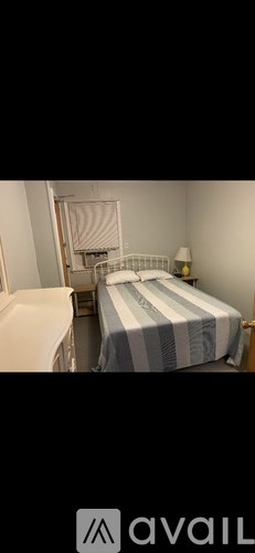 A bedroom with a bed and a nightstand.