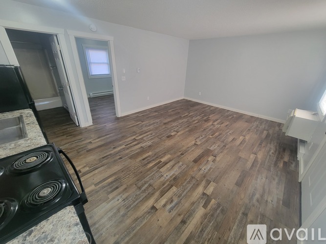 A room with wooden flooring and a stove in it.
