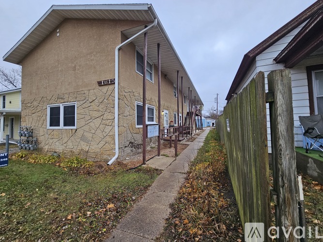 A brown building with a tree design on the side has the number 1615 on it.
