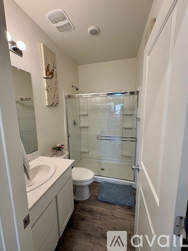 A bathroom with a toilet, sink, and shower.