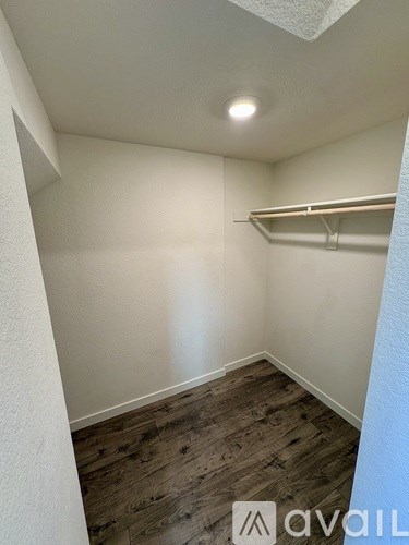 A room with a wooden floor and a shelf on the wall.