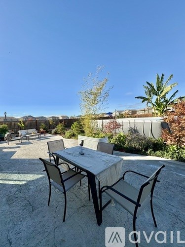 A patio with a table and chairs overlooking a residential area.
