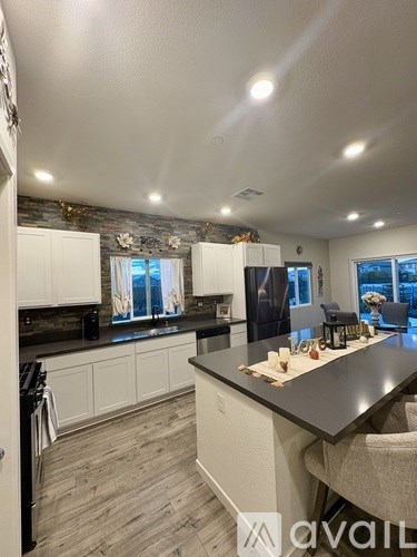 A modern kitchen with a black countertop and white cabinets.