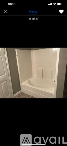 A white bathtub in a bathroom with a white door.