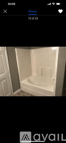 A white bathtub in a bathroom with a white door.