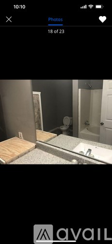 A bathroom with a wooden floor and a white toilet.