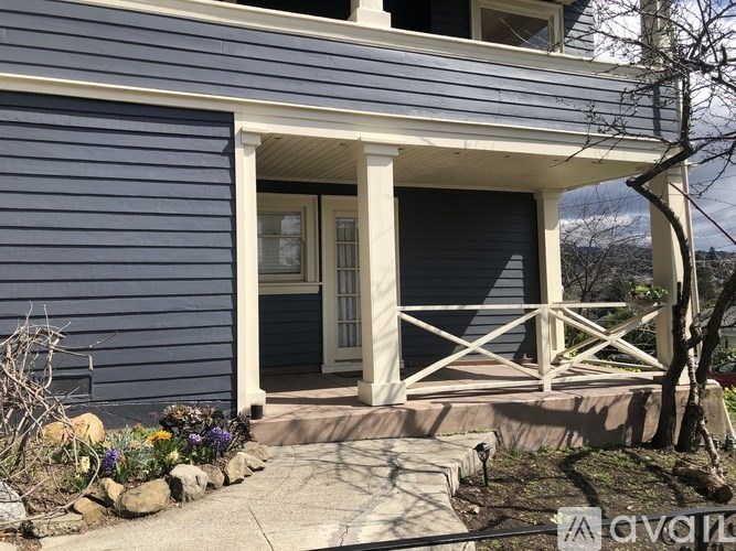 A blue house with a white door and a porch.
