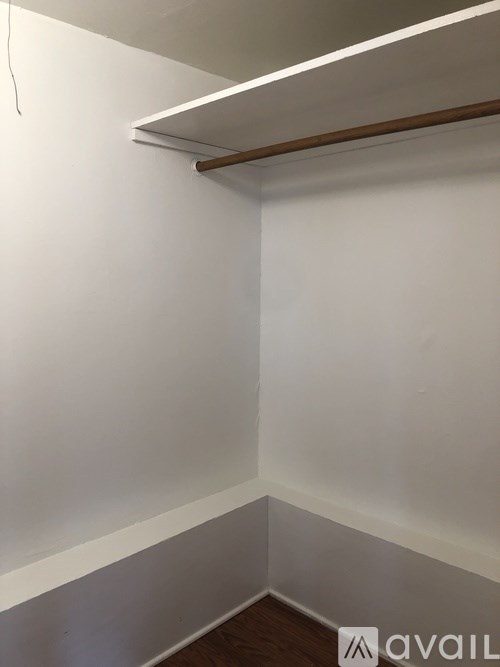 A white wall with a wooden shelf above it.