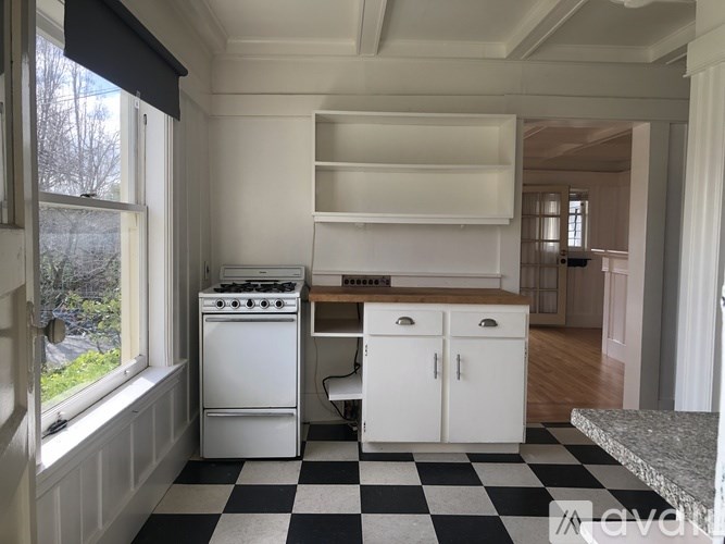 A kitchen with a black and white checkered floor.