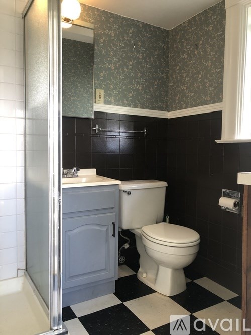 A bathroom with a toilet, sink, and black and white checkered floor.