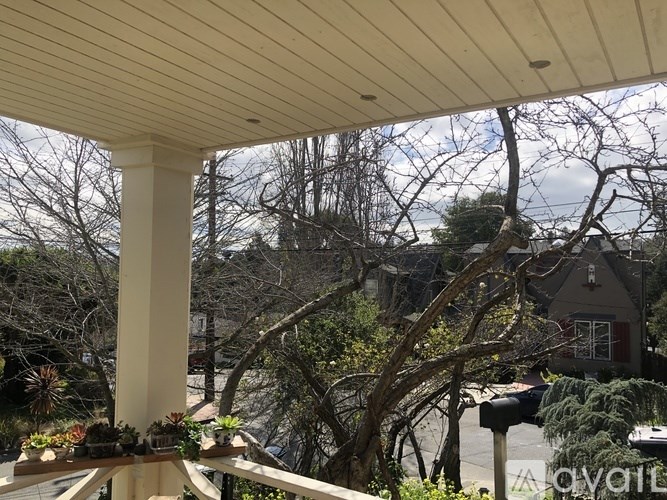 A porch with a wooden ceiling and a view of a residential area.