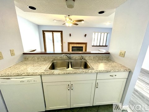 A kitchen with a granite countertop and white cabinets.
