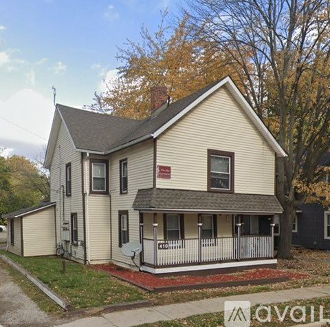 A two-story house with a red sign on the front.
