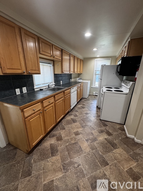 A kitchen with wooden cabinets and a white refrigerator.