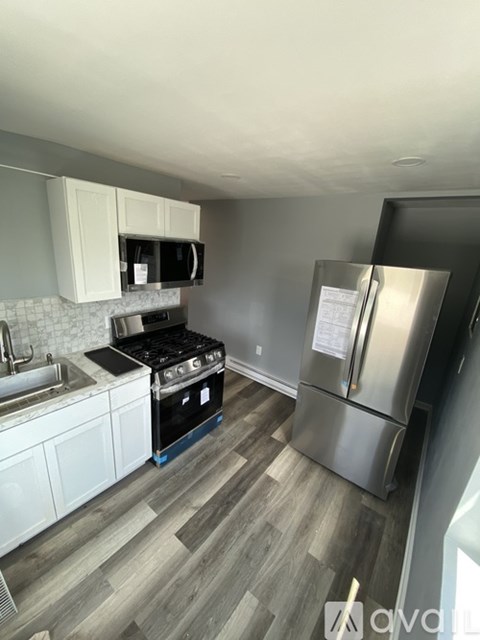 A kitchen with a stove, sink, and refrigerator.