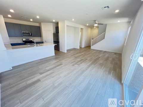 A spacious living room with a staircase leading to the upper floor.