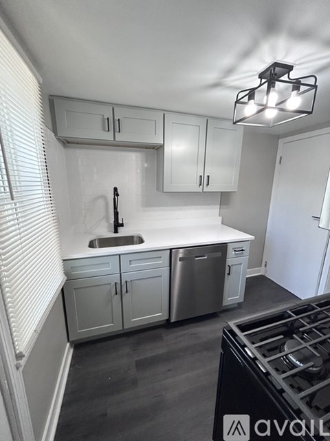 A kitchen with white cabinets and a black stove top.