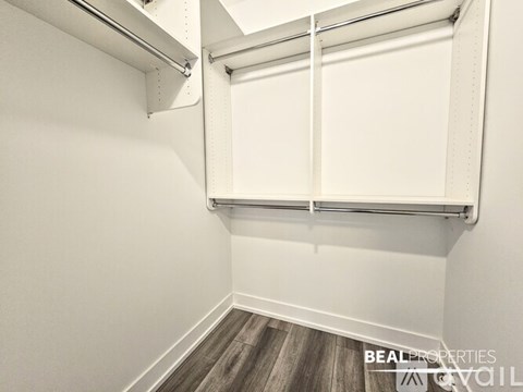 A white closet with a sliding door and a shelf above it.