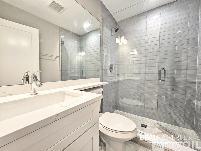A modern bathroom with a white toilet and a walk-in shower.