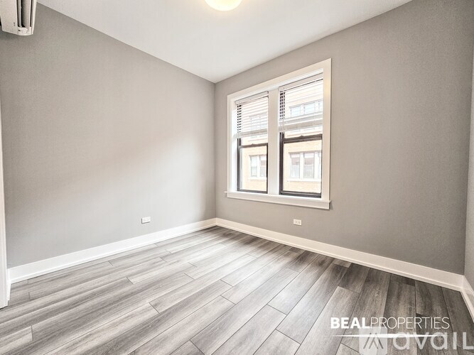 A room with a window and wooden flooring.