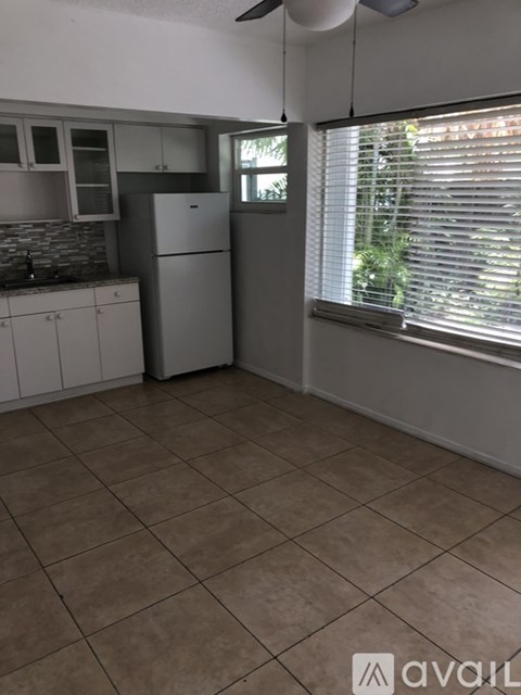 A kitchen with white cabinets and a tiled floor.