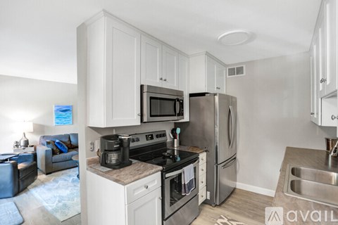 A kitchen with white cabinets and stainless steel appliances.