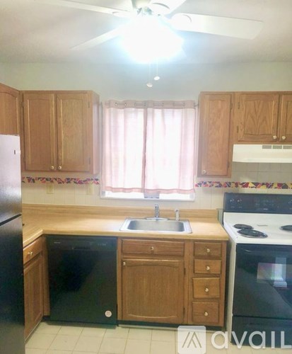 A kitchen with wooden cabinets and black appliances.