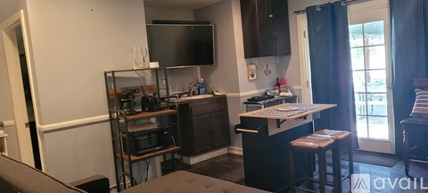 A kitchen with a black counter top and a black fridge.