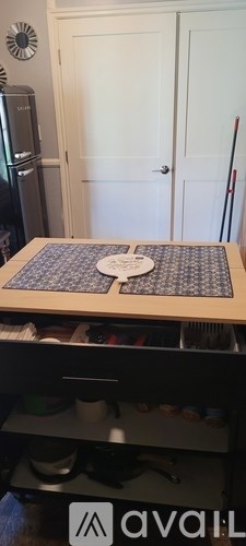 A kitchen with a refrigerator and a cabinet with a puzzle on top.