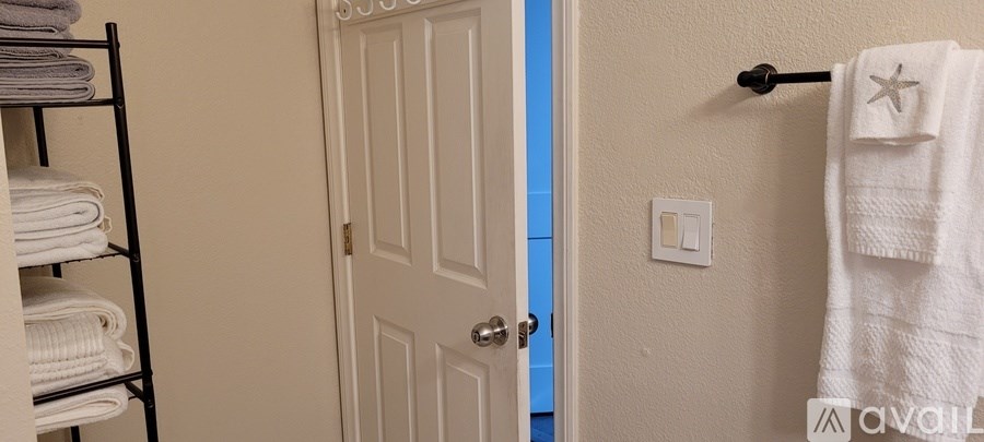 A white towel hangs on a towel rack in a bathroom.
