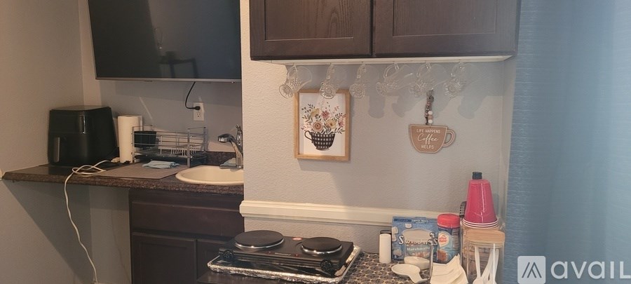 A kitchen with a black toaster and a black speaker on the counter.