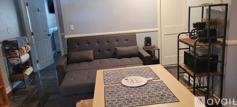 A grey couch with a wooden table in front of it.