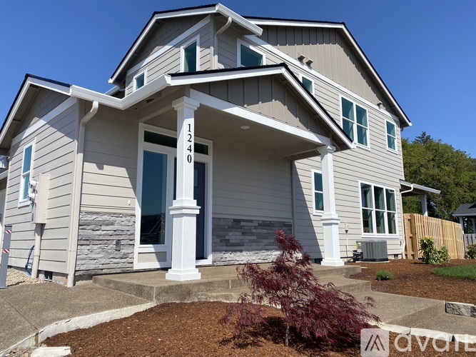 A two story house with a porch and a white pillar.