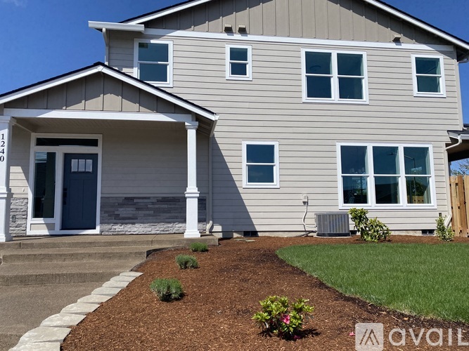 A house with a blue door and a grey siding.