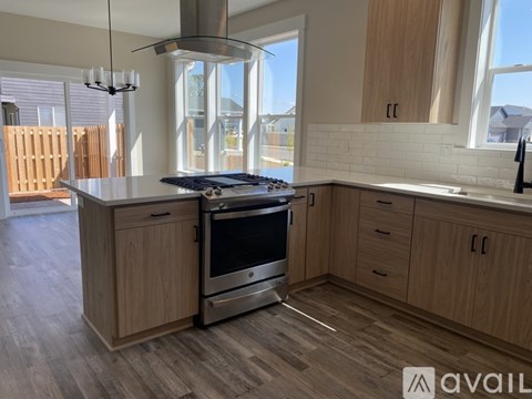 A modern kitchen with wooden cabinets and a stainless steel oven.
