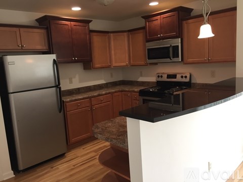 A kitchen with wooden cabinets and a black countertop.