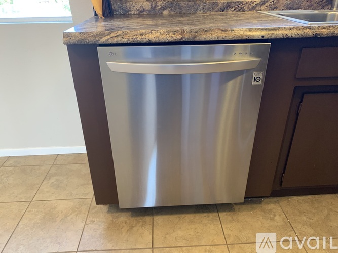 A stainless steel trash can is placed in a kitchen.