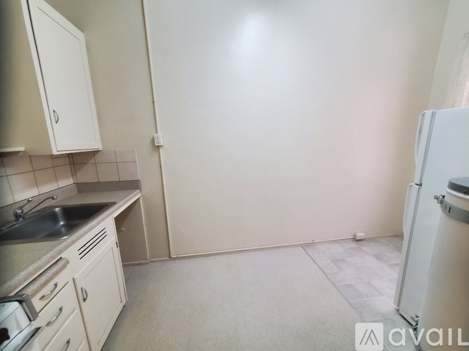 A kitchen with a sink, stove, and refrigerator.
