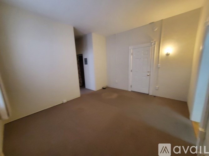 A room with a brown floor and white walls.