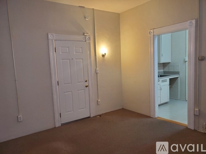 A room with a white door and a wall-mounted light fixture.
