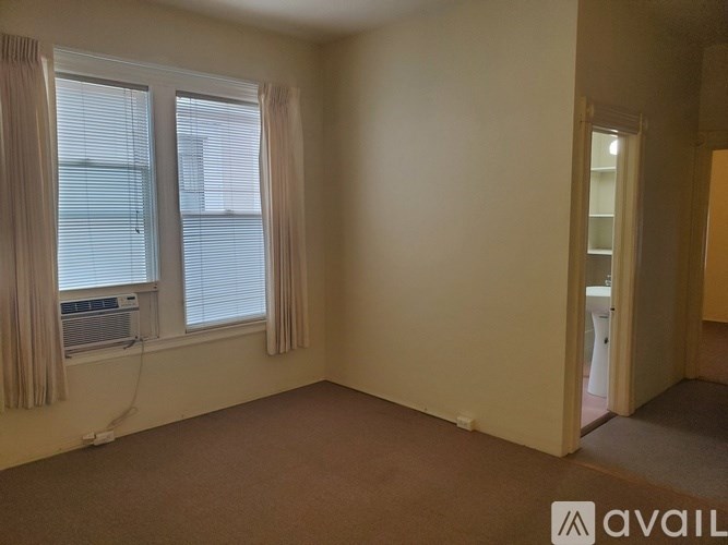 A room with a window and a door leading to another room.