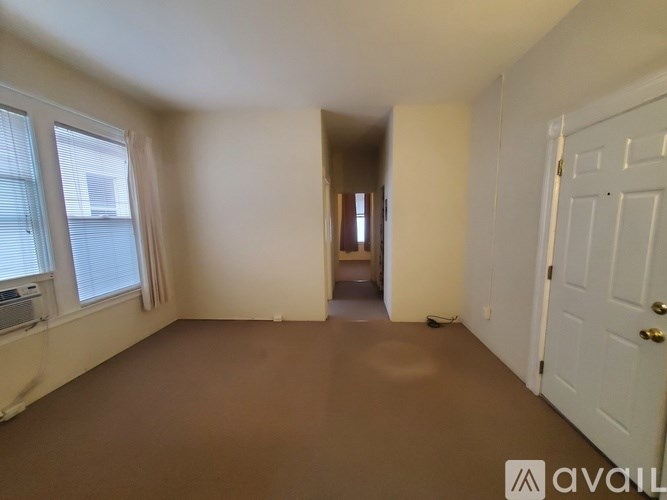 A room with a white door and a window with blinds.