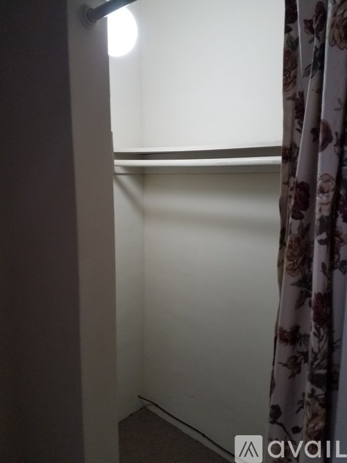 A room with a window and a curtain.