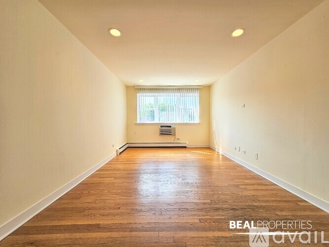 A long hallway with wooden floors and white walls.