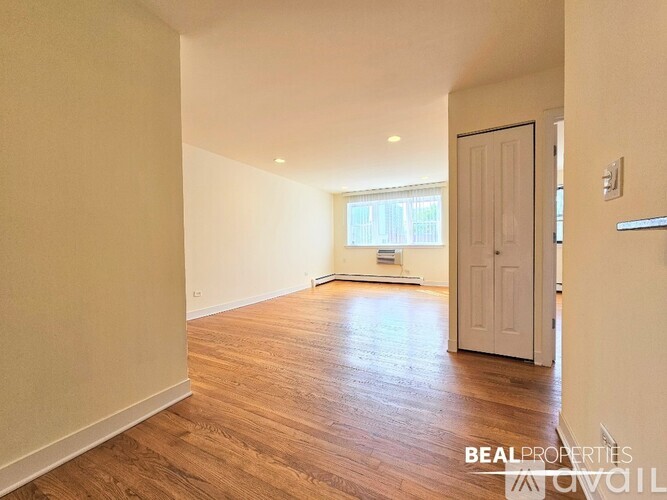 A room with a white door and a window in the background.