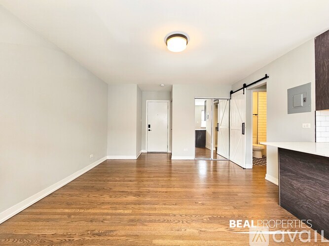 A kitchen with wooden floors and stainless steel appliances.