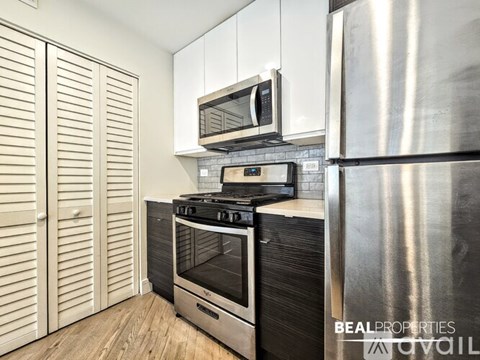 A modern kitchen with a stainless steel refrigerator, a stove, and a microwave above the oven.