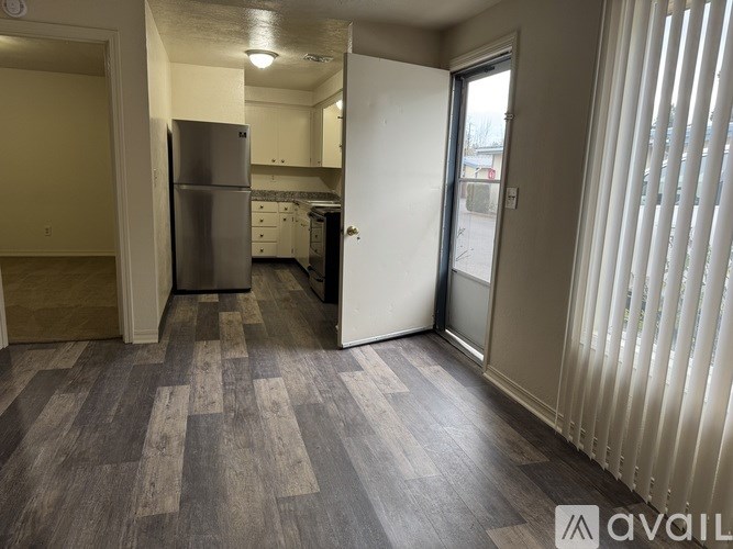A kitchen with a refrigerator and a dining table.
