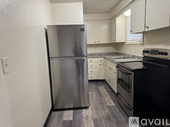 A kitchen with a stainless steel refrigerator and black stove.